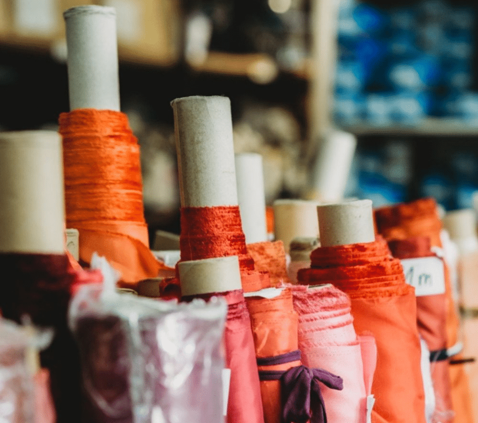 Wizualizacja rzędów materiałów na rolkach w kolorze pomarańczowym i różowym