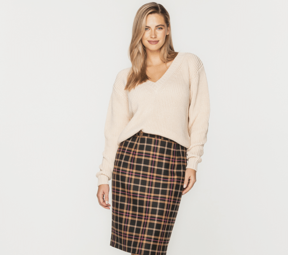 Wizualizacja kobiety w beżowym swetrze i spódnicy w brązową kratę