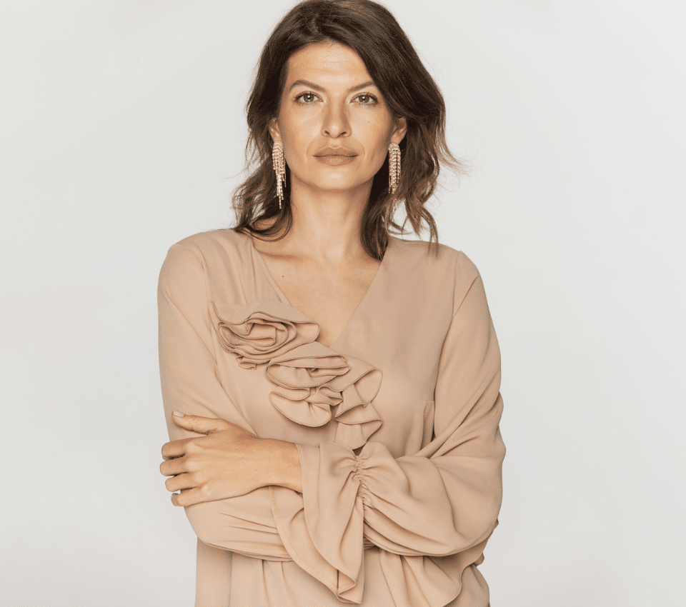 Wizualizacja kobiety w beżowej bluzce z dekoltem V i falbankami na ramieniu