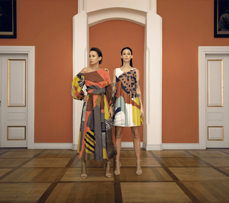 Wizualizacja dwóch kobiet w sukienkach z asymetrycznymi dekoltami w geometryczne wzory