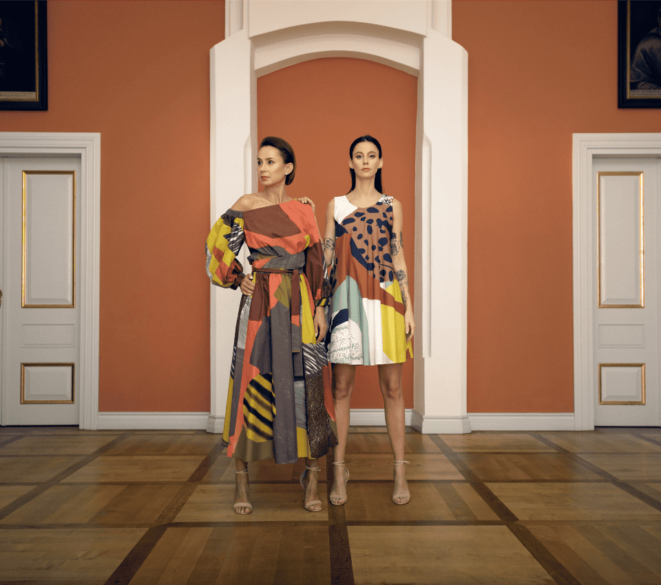 Wizualizacja dwóch kobiet w sukienkach z asymetrycznymi dekoltami w geometryczne wzory