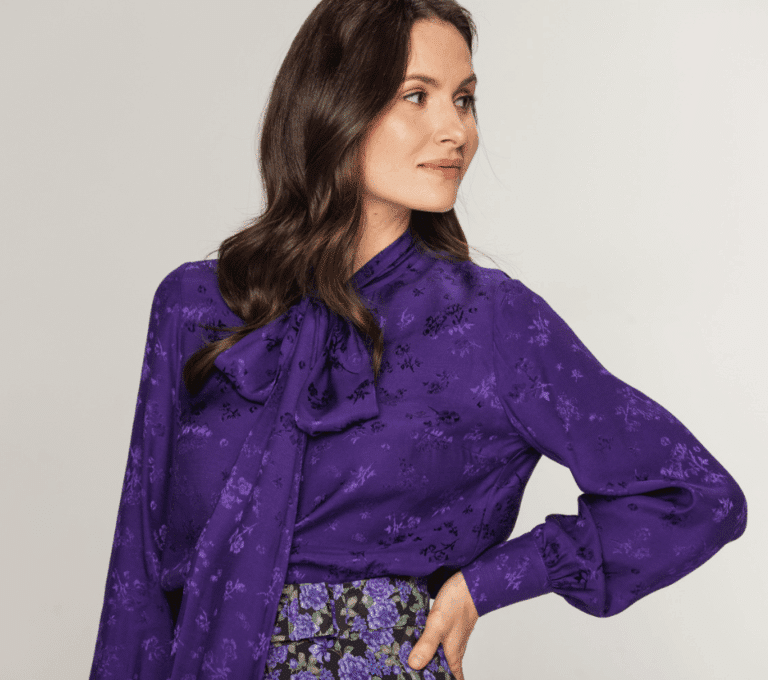 Wizualizacja kobiety w fioletowej bluzce z długim rękawem i wiązanym kołnierzem w jednolity wzór