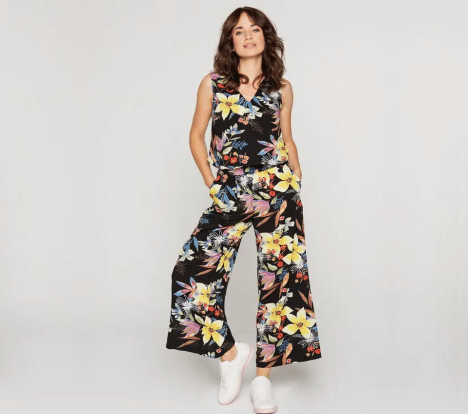 Wizualizacja kobiety w kombinezonie z szerokimi nogawkami w czarny tropikalny wzór