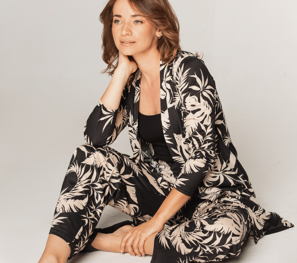 Wizualizacja kobiety w czarnym zestawie z marynarką i spodniami w kontrastowy wzór roślinny