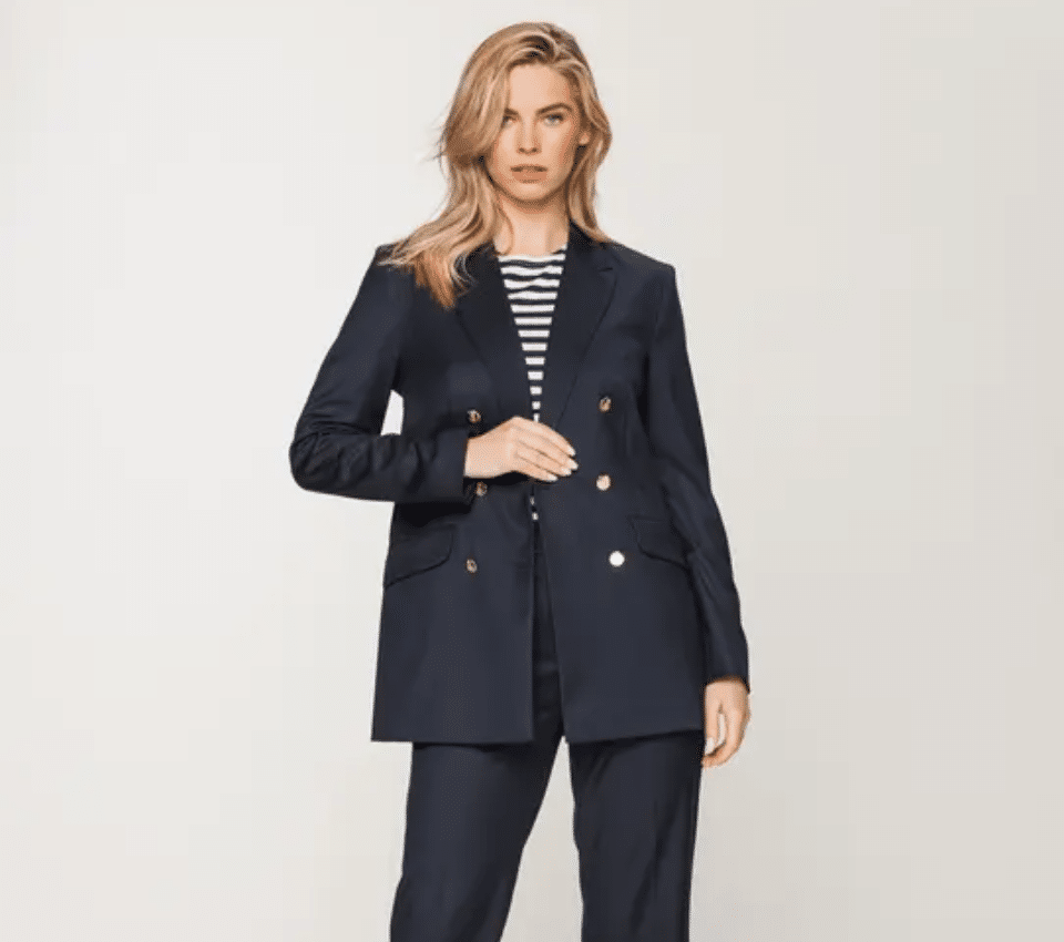 Wizualizacja kobiety w granatowej marynarce dwurzędowej ze złotymi guzikami i dopasowanymi spodniami