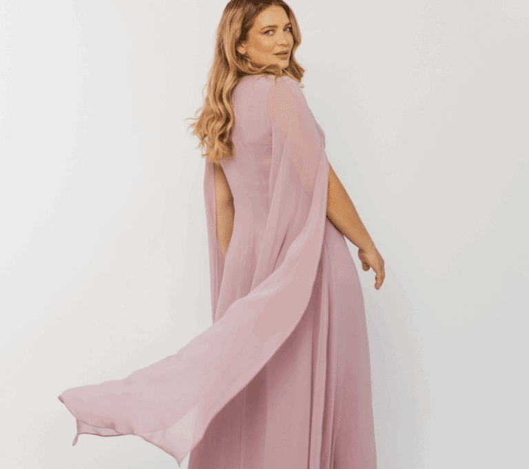 Wizualizacja kobiety w długiej, lejącej się sukni wieczorowej w kolorze pudrowego różu, z peleryną z szyfonu