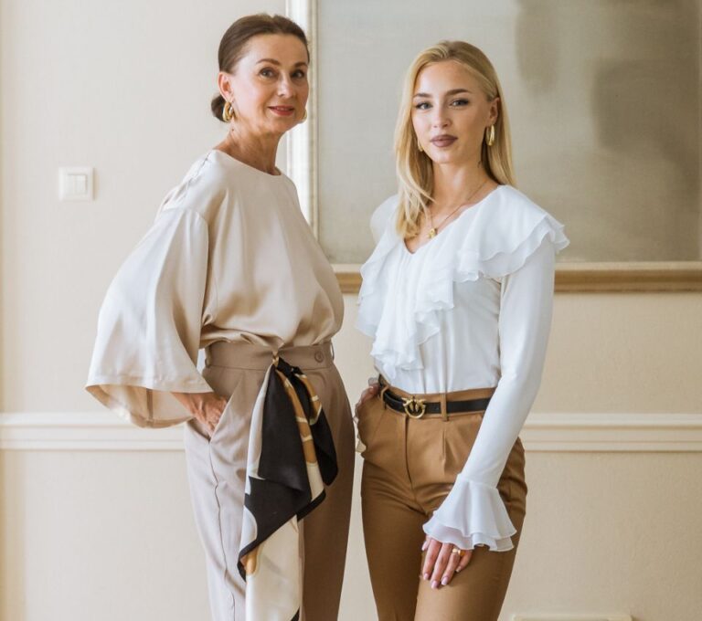 Wizualizacja dwóch kobiet w eleganckich stylizacjach, z beżowym topem i asymetryczną spódnicą oraz białą bluzką i brązowymi spodniami