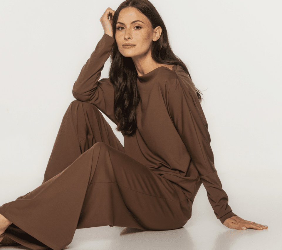 Wizualizacja kobiety w brązowym, dzianinowym kombinezonie z długim rękawem, luźną górą i szerokimi nogawkami