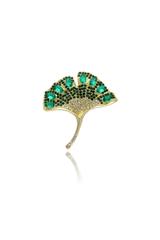 A gold brooch in the shape of a ginkgo leaf with green cubic zirconia stones