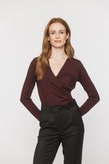 A burgundy knitted blouse with a wrap neckline and ruffles down the side