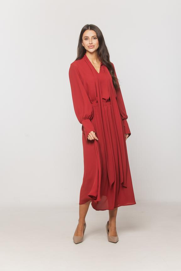 A dark red understated dress with decorative cuffs and a sash at the neckline